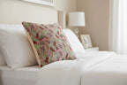 Housse de coussin en tapisserie aux motifs de fraises des bois sur un lit.