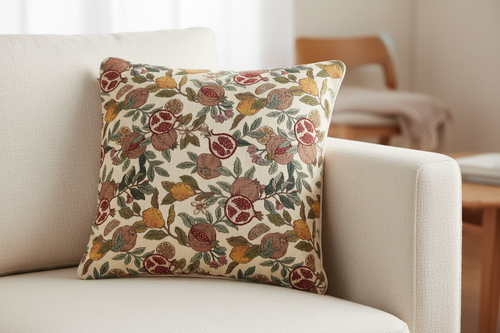 Housse de coussin en tapisserie motifs grenades et citrons sur canapé.