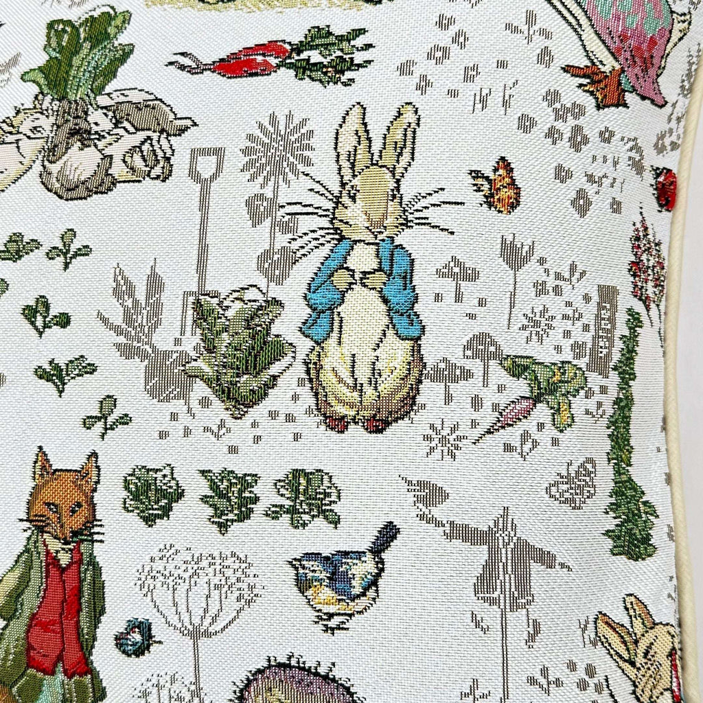 Housse de coussin en tapisserie avec les personnages de Pierre Lapin et du renard.