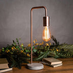 Lampe de table de style industriel en cuivre avec pied en pierre.