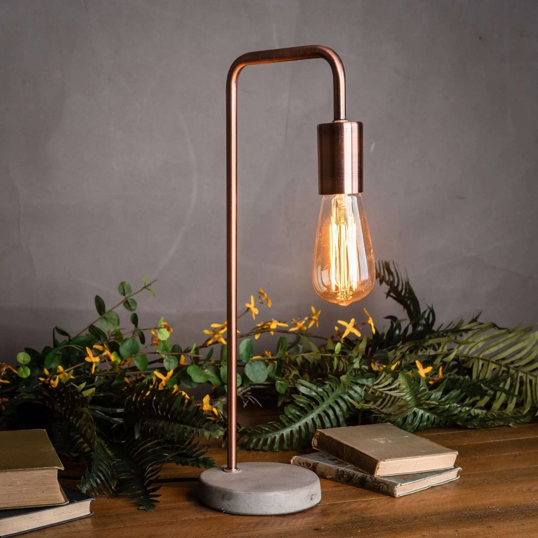Lampe de table de style industriel en cuivre avec pied en pierre.
