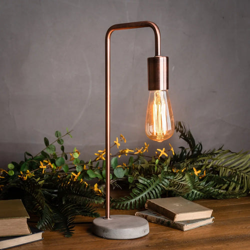 Lampe de table de style industriel en cuivre avec pied en pierre.