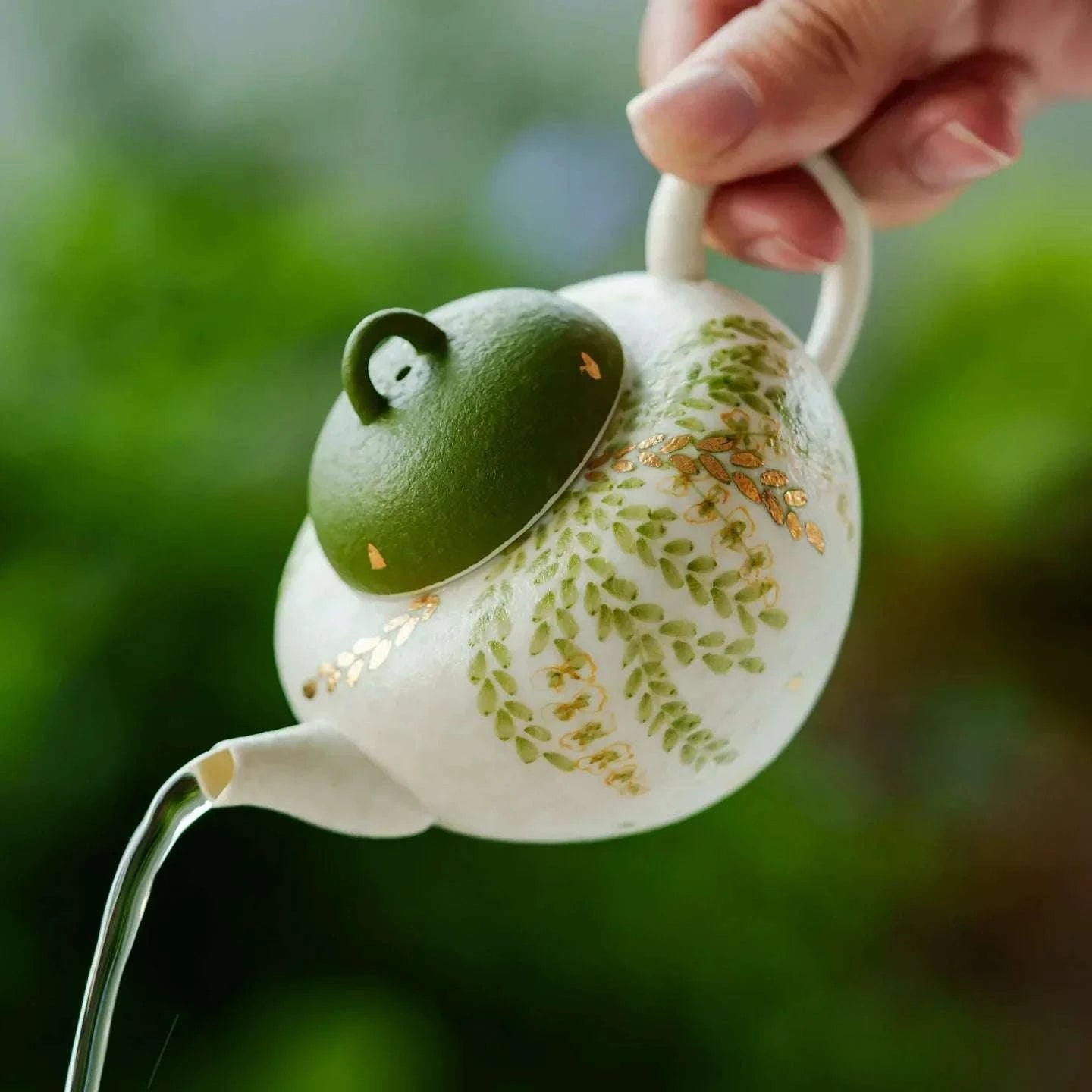 Petite théière en céramique artisanale, thé traditionnel chinois, motif feuilles vertes.