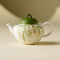 Théière artisanale en céramique 120ml avec motifs de feuilles vertes.