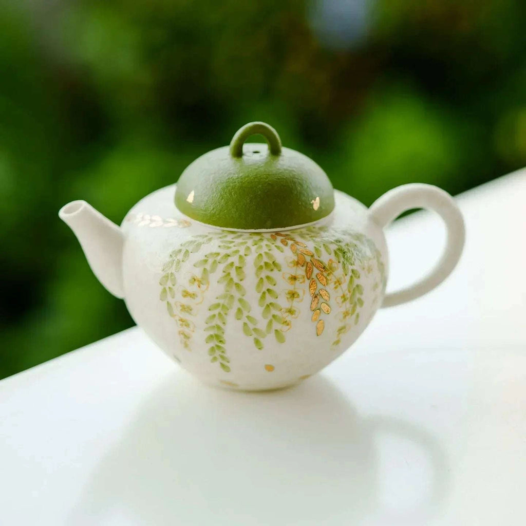 Théière artisanale en céramique pour rituel du thé chinois motif feuilles vertes.