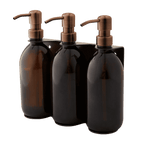 Triple distributeur de savon mural avec flacons verre ambré et pompe cuivrée.