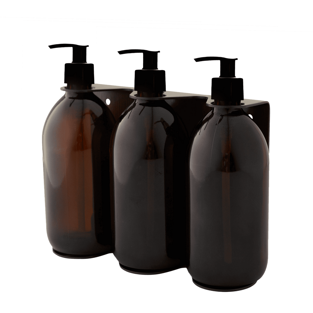 Triple distributeur de savon mural avec flacons verre ambré et pompe plastique noire.