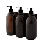 Triple distributeur de savon mural avec flacons verre ambré et pompe plastique noire.