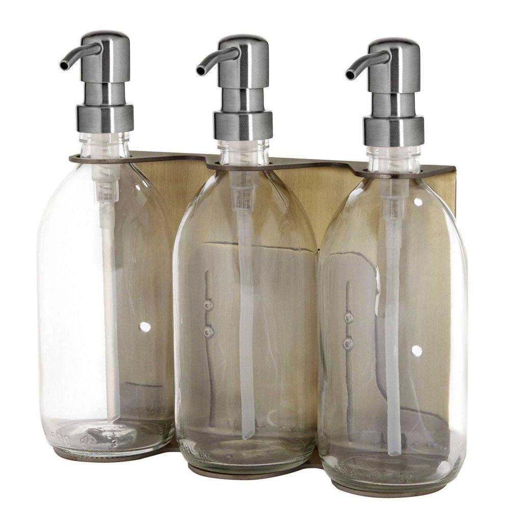 Triple distributeur de savon mural avec flacons verre transparent et pompe argentée.