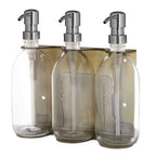 Triple distributeur de savon mural avec flacons verre transparent et pompe argentée.